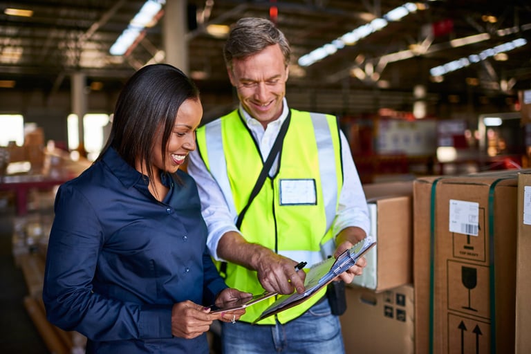 Shot of two warehouse workers using a digital tablet and looking at paperwork